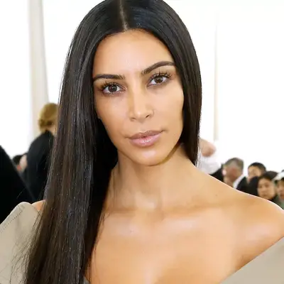 Kim Kardashian wears long, sleek hair with center part