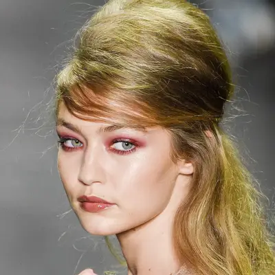 Gigi Hadid wears a half-up beehive hairstyle and red makeup