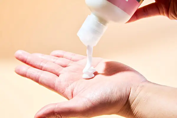 R+Co Dallas Biotin Thickening Conditioner being squeezed into a person