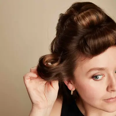 Woman wraps a section of hair into a curl