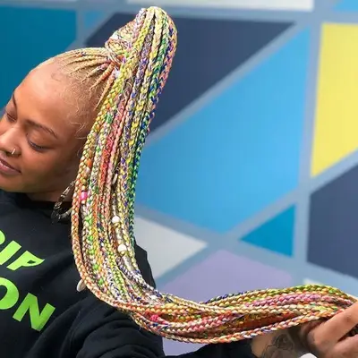 Rainbow multi-colored goddess braids in a high ponytail
