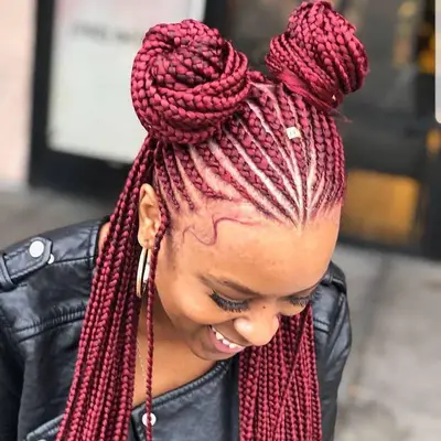 Red goddess braids tied into half-up/half-down space buns
