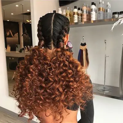 Goddess braids with copper brown curly ends braided into two pigtails 