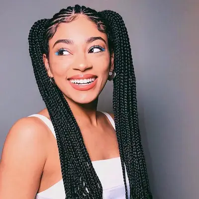 Black goddess braids tied into two high pigtails