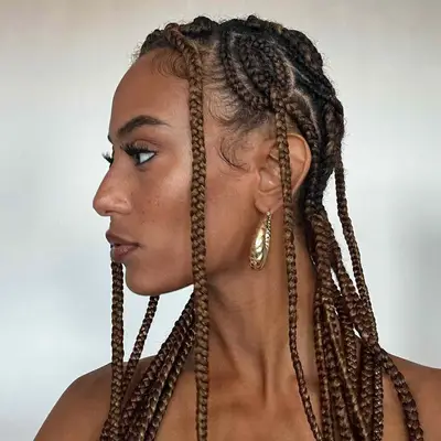 Light brown goddess braids done with an intricate pattern at the scalp