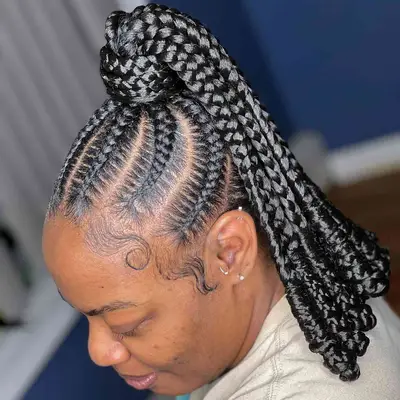 Thick goddess braids worn in a high ponytail with coiled curly ends