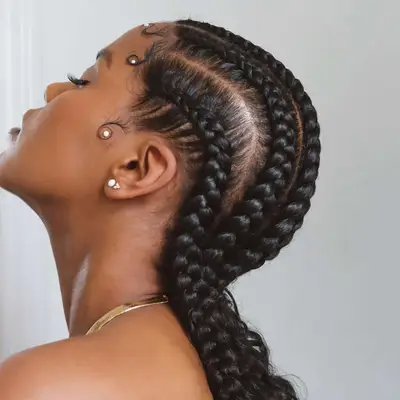 Thick goddess braids worn slicked back with pearl embellishments on the baby hairs