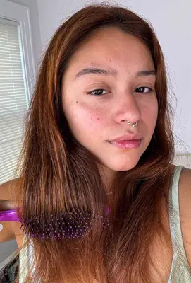 A person uses the Wet Brush Original Detangler Hair Brush