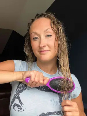 A person uses the Wet Brush Original Detangler Hair Brush