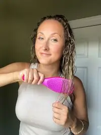 A person brushes their hair with the Tangle Teezer The Ultimate Detangler