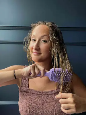 A person uses the Fhi Heat UNbrush Detangling Hair Brush
