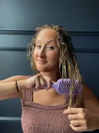 A person uses the Fhi Heat UNbrush Detangling Hair Brush