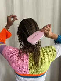 A person uses the Denman D38 The Detangling & Styling Paddle