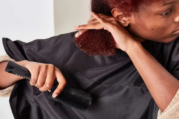 A person brushes their hair using the Drybar Super Lemon Drop Daily Detangler Brush