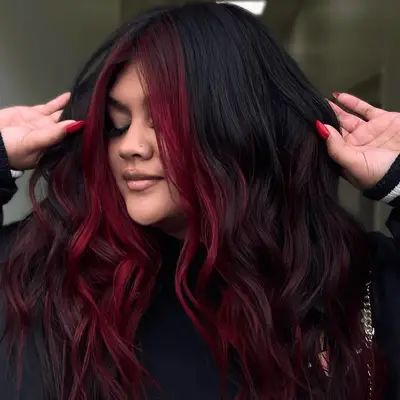 Model with black hair and cherry money piece front layers.