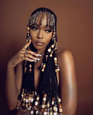 Black woman wearing full head of beaded braids