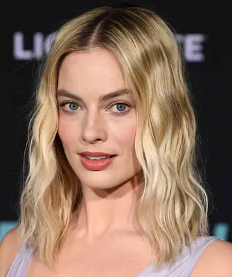 Margot Robbie with blonde waves and a shadow root
