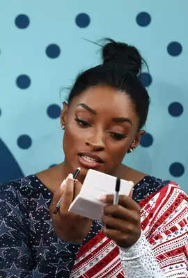 Simone Biles touching up her makeup at the Paris Olympics