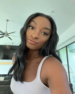 Simone Biles with a wavy hairstyle. 