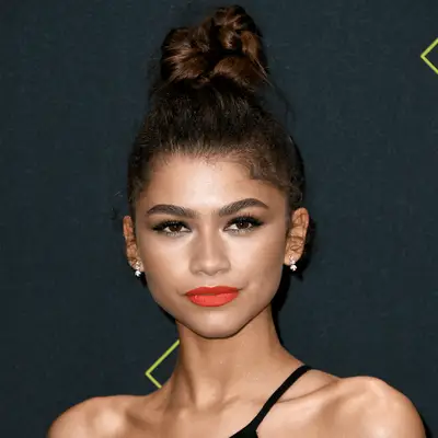 Zendaya with red lipstick and twisted topknot 