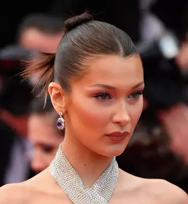 Megan Thee Stallion wearing bright red hair pulled back into three spikes surrounding her bun