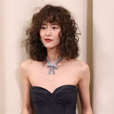 Liu Wen on a red carpet with curly bob with bangs