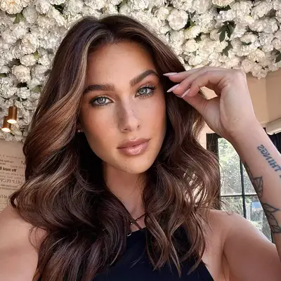 Woman posing touching her hair brunette, wavy hair 