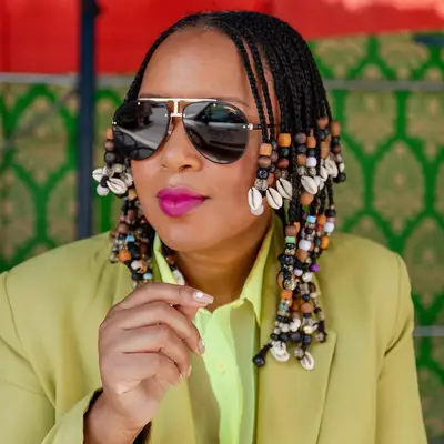 Tiffany Battle posing in sunglasses with layered braids with multicolored beads