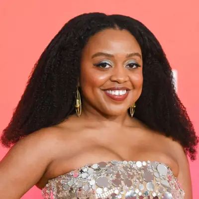 Zendaya wearing a sparkly knit top and a black blazer with her hair styled in a side-part blowout 