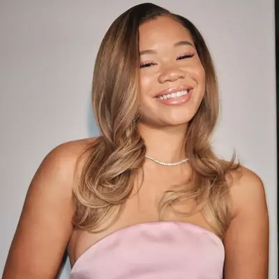 Storm Reid with bronde curled hair in side part