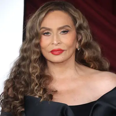 Tina Knowles with side part bronde curly hair