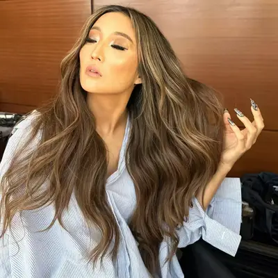 Ashley Park with long bronde wavy hair