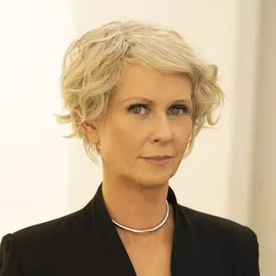 Cynthia Nixon looking at the camera, wearing elegant attire