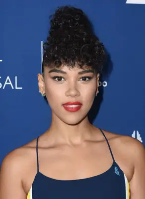 Alexandra Shipp with a curly high bun and matching curly fringe at the 2018 Rising Stars at the GLAAD Media Awards Los Angeles
