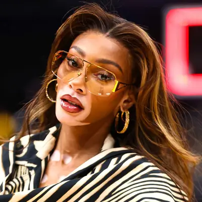 Winnie Harlow wears long golden brown hair with chunky highlights