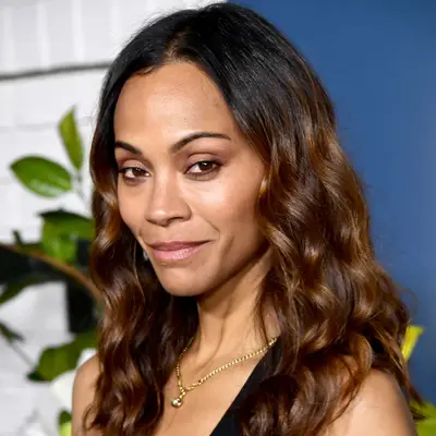 Zoe Saldana wears golden brown on her midshaft and ends with natural dark roots