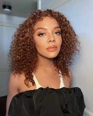 Close up of Tessa Thompson with curly cowgirl copper hair