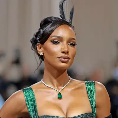 Jasmine Tookes with hair in a bun and a subtle bouffant on top.