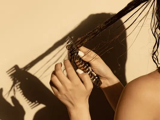Long haired model combing tangled, wet hair.