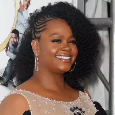 Jill Scott wearing cornrows on one side and curls