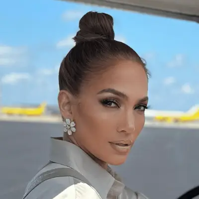 Jennifer Lopez with sleek topknot and large floral earrings