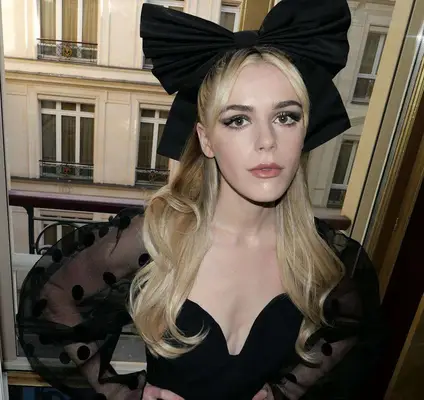 A half-up hairstyle with large black bow