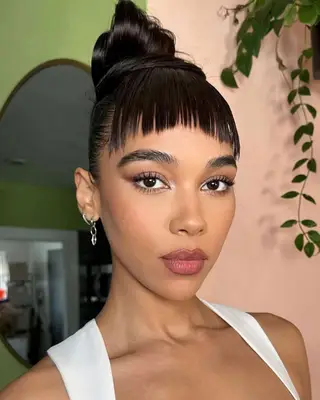 Sleek top-knot bun with piecey bangs