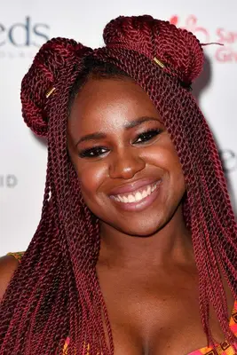 NAO with red long braids styled into a half-up, half-down space bun look.