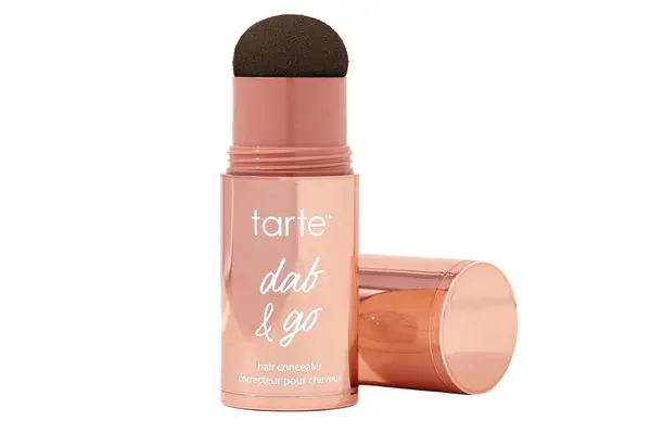 A person holds up the Bumble and bumble Color Stick with the cap off