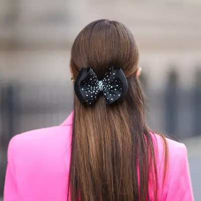 A sparkly black bow in the back of a woman