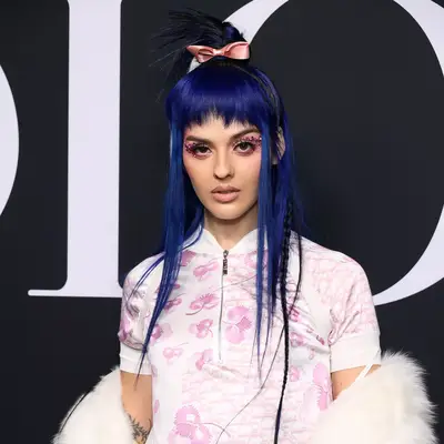 Close up of Lily-Rose Depp wearing a high curly ponytail with black micro bows.