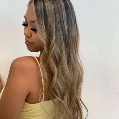 Back view of woman with silver-toned blonde balayage with dark roots