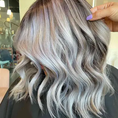 Side view of layered blonde hair with platinum silver balayage