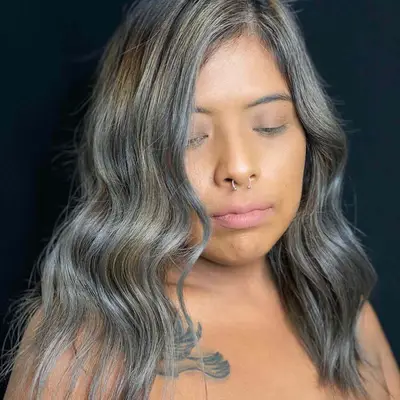 Woman with cool-toned brunette hair with blonde and silver balayage